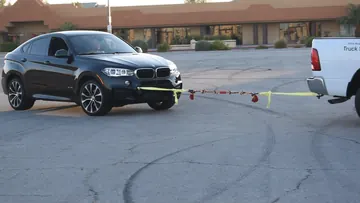 Front view of the SUV and pickup with the BLINCOO rope between them