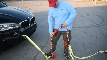 Person holding the BLINCOO rope beside a vehicle